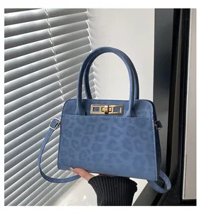 Détail du sac cabas en daim bleu à motif léopard avec fermoir tournant doré élégant