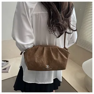 Detailed view of brown cloud bag with rhombus texture and metal logo on suede leather