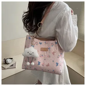 Close-up of pink butterfly print tote bag with quilted texture and cloud charm detail