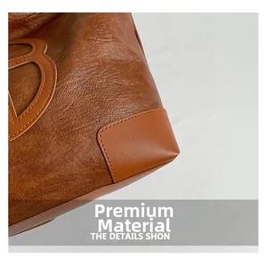 Détail macro du sac cabas en cuir marron avec grand logo B et coutures premium