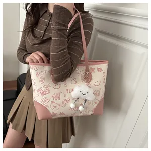Detail of printed tote bag featuring pink illustrations and plush cloud pendant charm