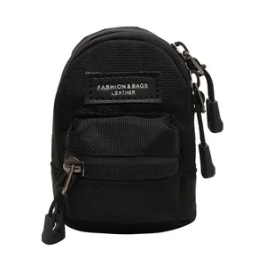 Mini black nylon backpack-style crossbody bag with textured honeycomb pattern and zip pouch