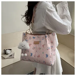 Detail of pink butterfly tote bag featuring a smiling white plush cloud charm and handles