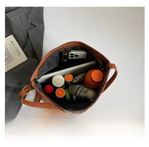 Vue intérieure du sac cabas en cuir marron montrant sa grande capacité pour iPad et objets