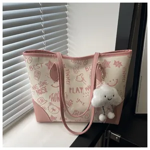 Detail of printed tote bag with pink graffiti patterns and plush cloud keychain charm