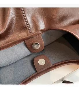 Dettaglio della chiusura magnetica argento e fodera in pelle marrone della borsa