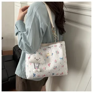 Model wearing a white floral butterfly tote bag with gold chain strap and cloud charm