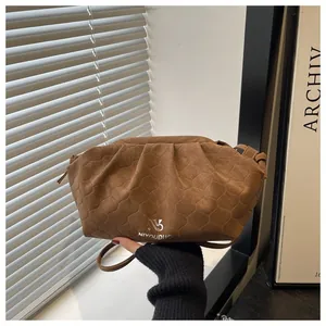 Detail of brown cloud bag featuring honeycomb quilted texture and silver metallic logo