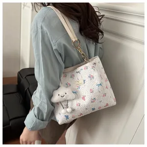 Detail of floral butterfly tote bag with plush cloud pendant on shoulder strap