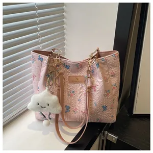 Detail of floral butterfly tote bag featuring a plush cloud charm and gold chain strap