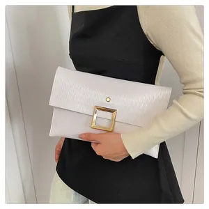 Détail de la pochette enveloppe en cuir épi blanc avec un fermoir carré doré