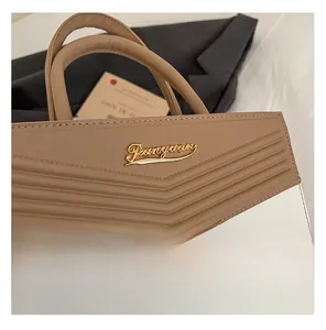 Close-up of khaki leather handbag featuring 3D ribbed texture and golden metal logo