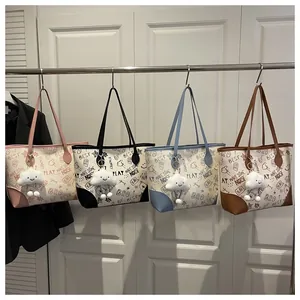 Detail view of printed tote bags in pink black blue and brown with cloud charms