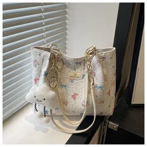 Close-up of butterfly tote bag texture with golden chain strap and plush charm