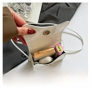 Capacité intérieure détaillée montrant des objets du quotidien dans un sac en cuir verni