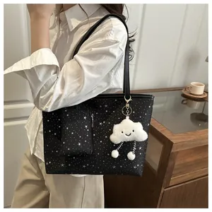 Close-up of black star pattern tote bag with plush cloud charm and mini pouch