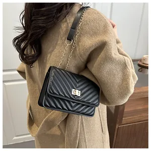 Détail du sac bandoulière noir matelassé avec fermoir rotatif doré et bandoulière