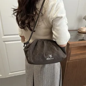Minimalist dark brown cloud bag with honeycomb quilted texture and slim strap