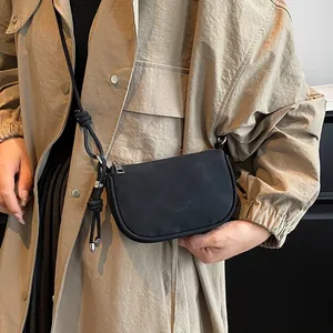 Minimalistische schwarze Wildleder-Achseltasche mit Knotenseil und Metallanhänger-Detail