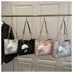 Detail showing four colors of butterfly floral tote bags with plush cloud charms and chain straps