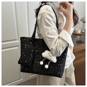 Detail view of black tote bag with white star pattern and cute cloud plush pendant charm