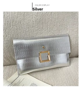 Pochette enveloppe argentée avec texture ondulée et boucle carrée dorée en détail