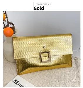 Vue détaillée d'une pochette dorée type enveloppe avec boucle métallique sur similicuir