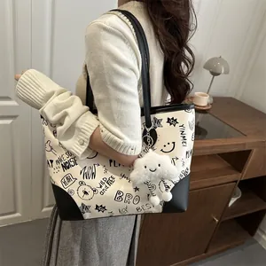 Fashionable large capacity tote bag with black graffiti print and white plush charm