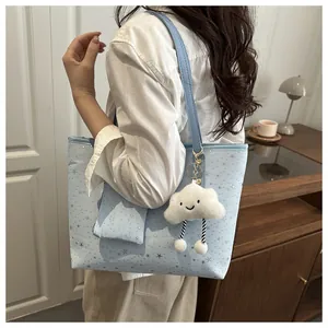 Detail of light blue star pattern tote bag with matching pouch and cloud charm pendant