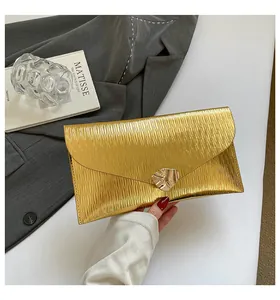 Détail de la pochette enveloppe dorée avec texture métallique et plis ondulés