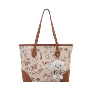 Fashionable tote bag with graffiti prints, brown trim and cloud charm on white background