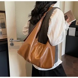 Dettaglio della borsa hobo caramello con trama in pelle e tracolla larga integrata