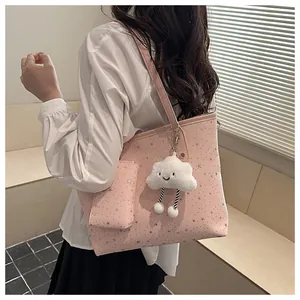 Pink star-patterned tote bag with mini pouch and cloud charm shown on shoulder