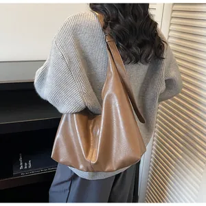Dettaglio della borsa hobo marrone con texture a grana e tracolla larga regolabile