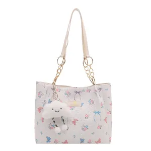White floral tote bag with butterfly prints, golden chain straps, and cloud charm
