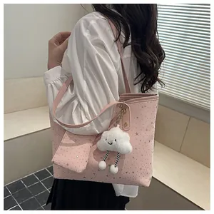 Detailed shot of a pink tote bag with star patterns and a fluffy white cloud charm