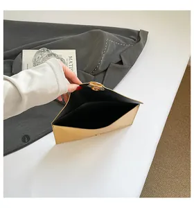 Vue détaillée de la pochette enveloppe dorée avec fermeture magnétique et doublure noire