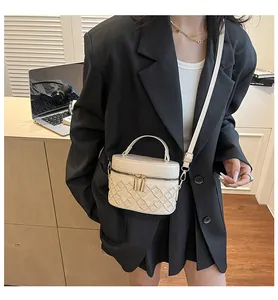 White quilted cosmetic box bag with gold zippers worn by model in professional office setting