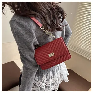 Close-up of red V-quilted chain bag showing metallic turn-lock and premium PU texture