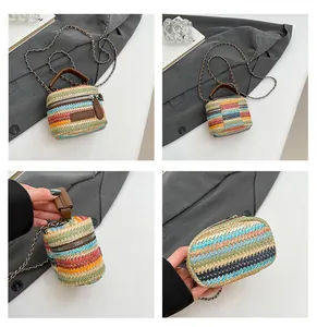 Detailansicht einer bunten Strohtasche mit Regenbogenstreifen und Ledergriff im Fokus