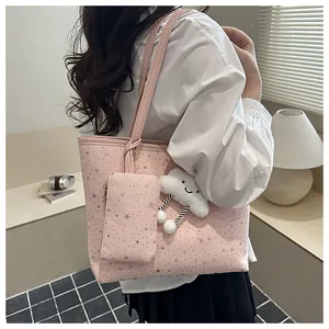 Pink tote bag detail with star pattern, small pouch and white cloud plush charm