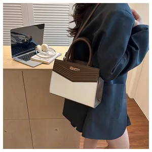 Detailed view of women's handbag with V-shaped embossing and brown contrast trim