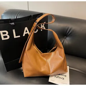 Dettaglio borsa hobo in pelle PU caramello con tracolla regolabile e fibbia in metallo