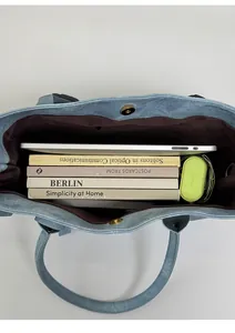 Top view of spacious interior of light blue tote bag with magnetic closure and laptop