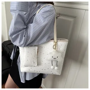 White star pattern tote bag with coin purse and cloud charm shown on shoulder