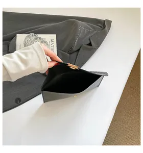 Vue détaillée de l'intérieur d'une pochette enveloppe noire avec boucle dorée mate