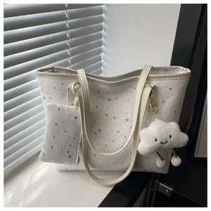 Detail of white tote bag with grey stars featuring a plush cloud charm and a matching pouch