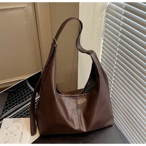 Dettaglio macro della borsa hobo caffè con trama in pelle lucida e cuciture rifinite