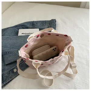 Detail of strawberry corduroy tote bag showing magnetic closure and interior storage space