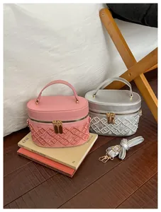 Detail of embroidered quilted makeup bags with crown patterns in pink and silver
